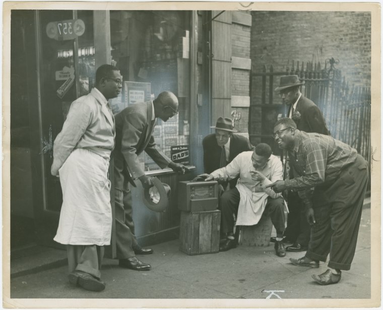 Old days in Harlem (Gallery and Videos) 6 Old days in Harlem: Harlem residents in front of shop listening to the radio
